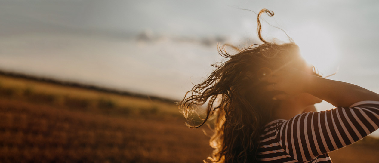 Woman in a field soaking up the afternoon sunshine
