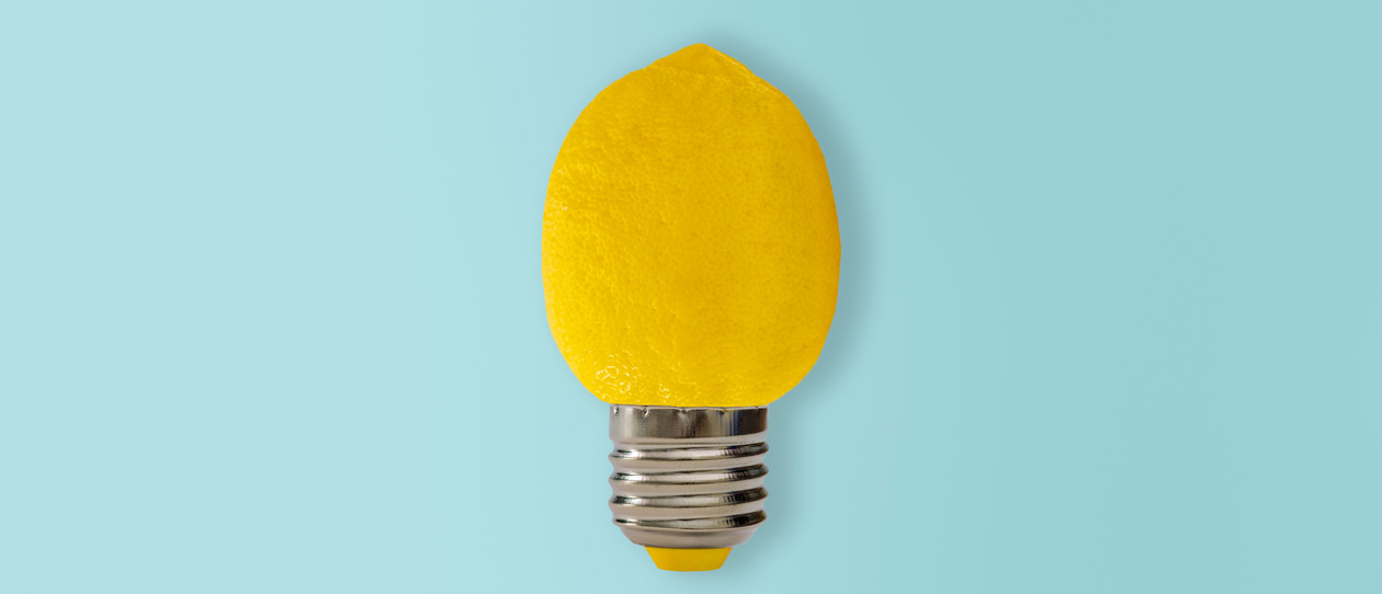 Fresh lemon in the shape of a light bulb on a light blue background