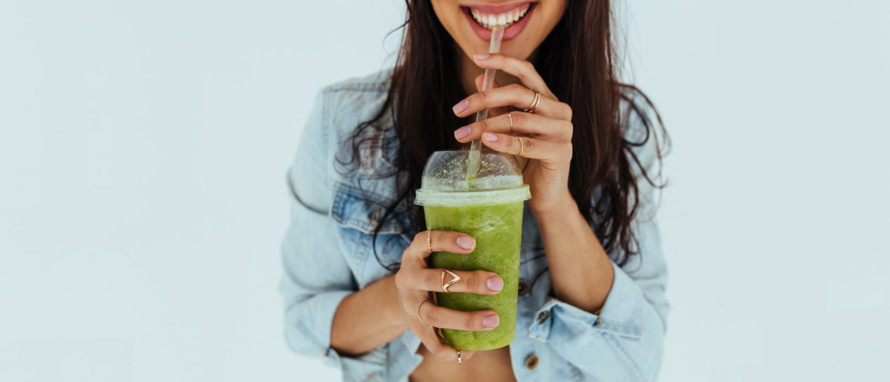 Healthy woman drinking a green juice