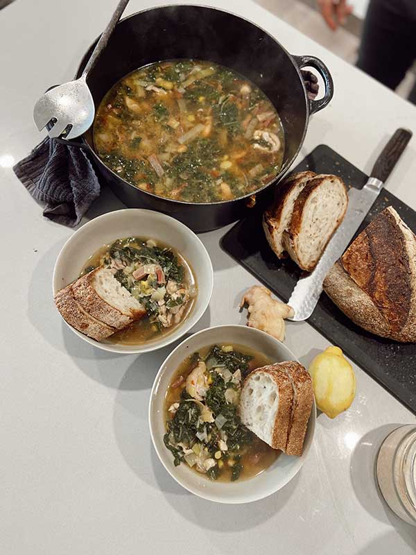 Chicken, ginger and corn nourishing soup in bowls with bread
