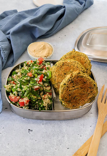 Falafel bites with quinoa tabouli and hummus in a metal lunchbox