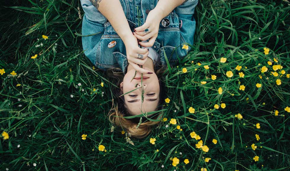Woman lying on her back in a meadow
