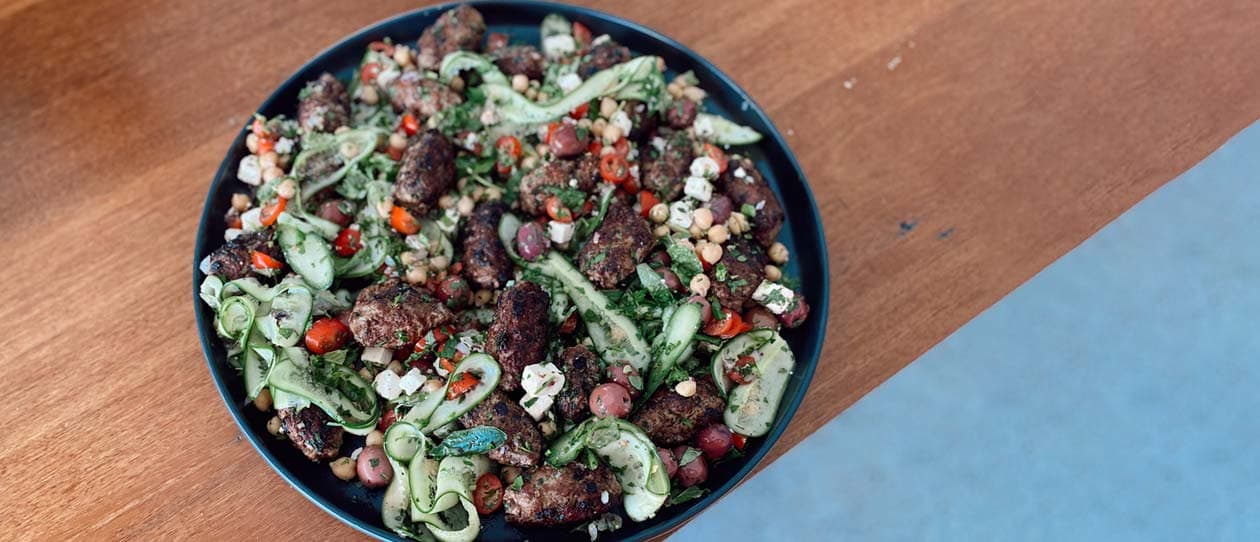 Flay lay image of lamb kofta and Greek salad