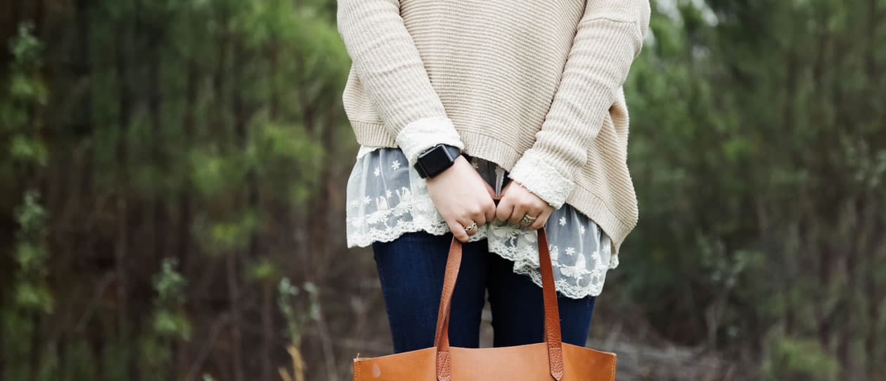 Woman standing in the forest holding a bag