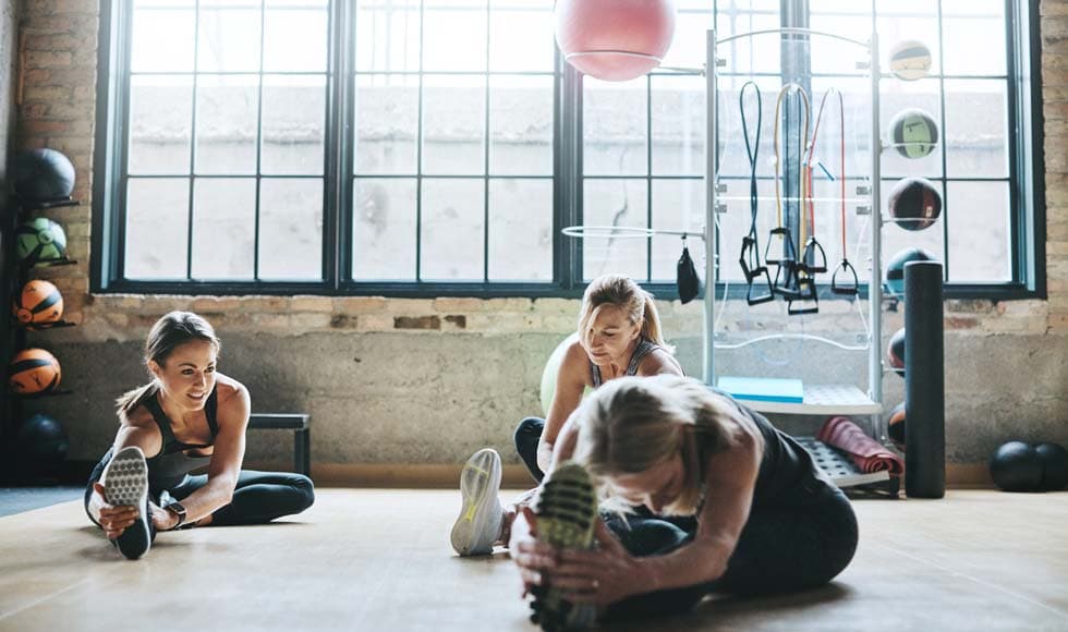 Three women stretching in the gym