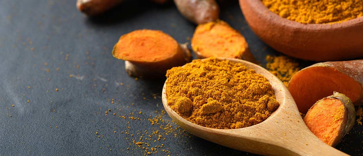 Curcumin powder in a wooden spoon