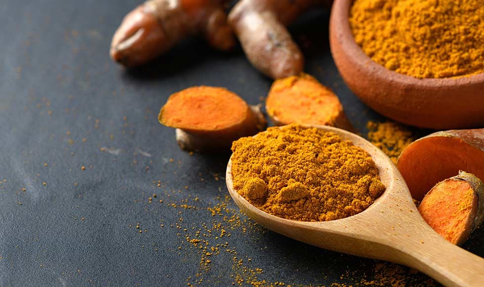 Curcumin powder in a wooden spoon