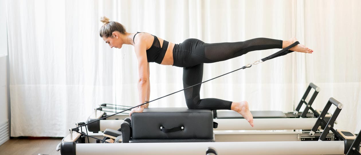 Woman exercising on a Piltaes reformer
