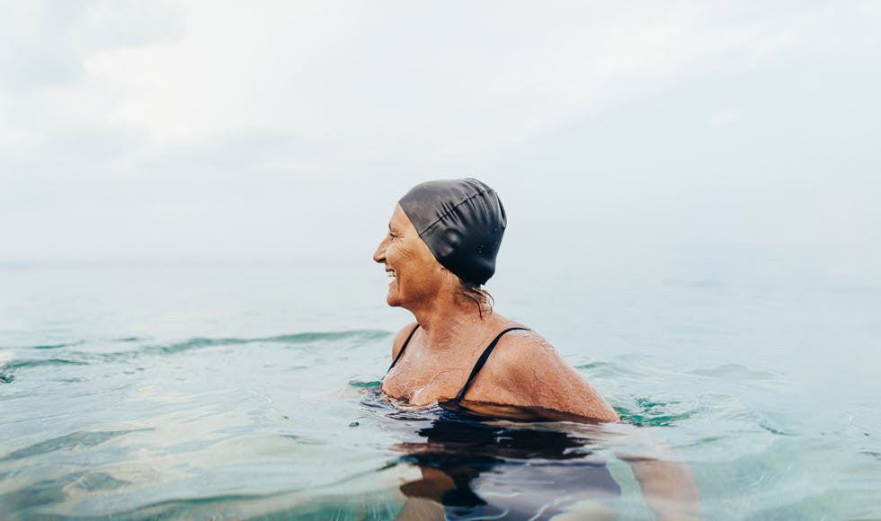 Woman in a black swimming cap enjoying an ocean swim