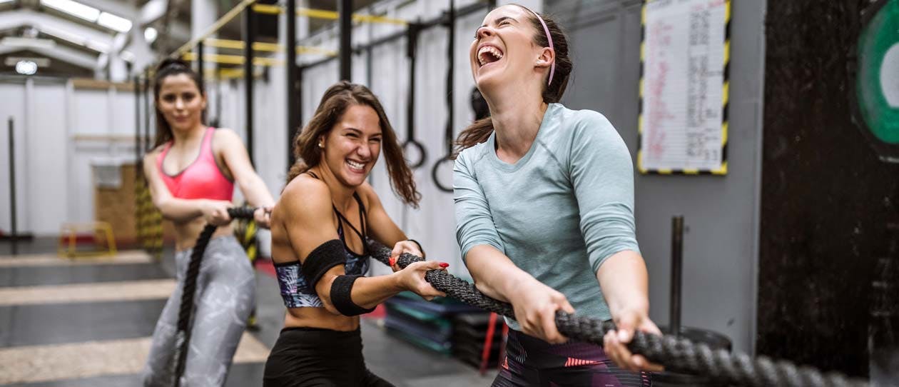 Three women laughing in a cross fit class