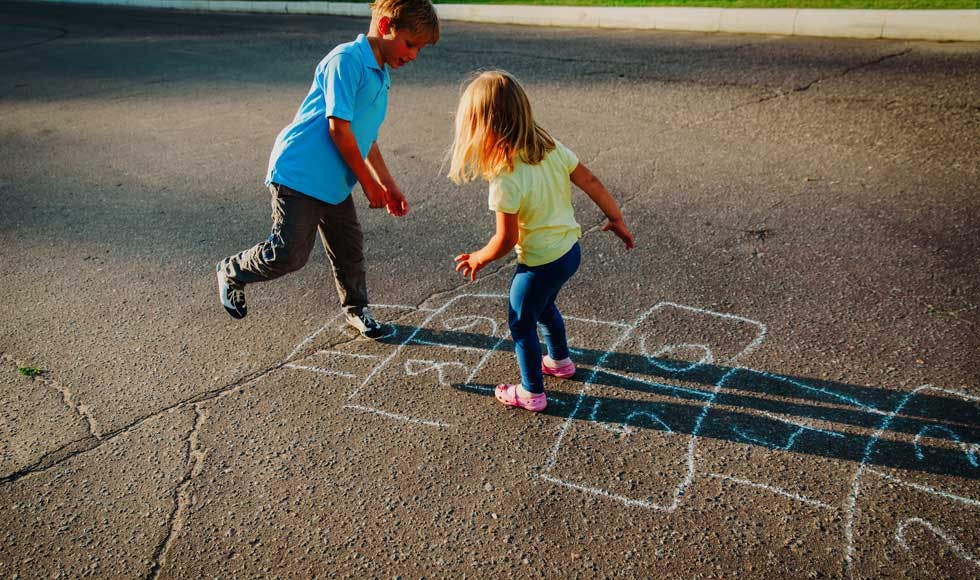 Sister and brother playing hopscotch