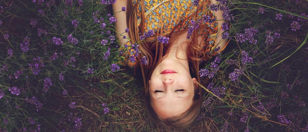 Young woman lying on the ground on a field of purple flowers