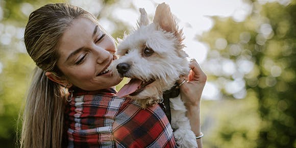 Young woman cuddling white terrier